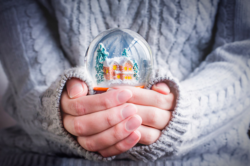 Χέρια κρατούν χιονόμπαλα σε γυαλί, ένα από τα πιο κλασικό δώρο Χριστουγέννων.